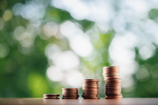 Coins put in order on a wooden table virtual, the growth of the concept and business strategy with natural green background.