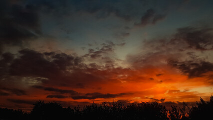 Fototapeta na wymiar Bright red orange sunset in the clouds