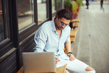 Busy freelancer making notes during online conference