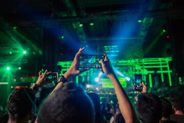 Faceless people recording video on smartphones during live concert