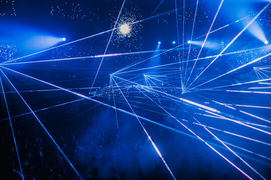 Bright neon rays in dark concert hall