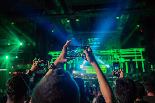 Faceless people recording video on smartphones during live concert
