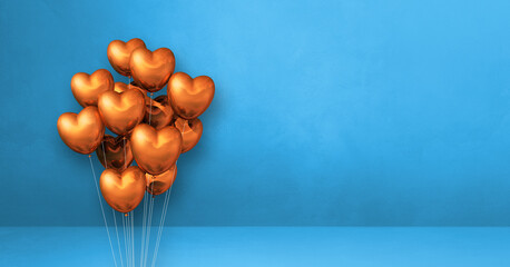 Copper heart shape balloons bunch on a blue wall background. Horizontal banner.