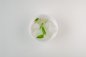 Full plate of ice with mint on white background