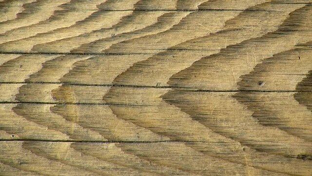 Close-up of rustic wooden plank with cracks and prominent wood grain.
