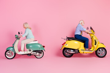 Fototapeta na wymiar Full size profile side photo of happy positive smiling mature married couple ride moped isolated on pink color background