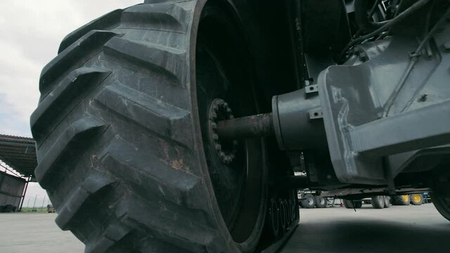 Tractor wheels and transmission operation. View of the tractor from below. Repair of large dimensional equipment.