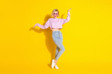 Full length photo of funky positive young woman dance good mood isolated on bright yellow color background