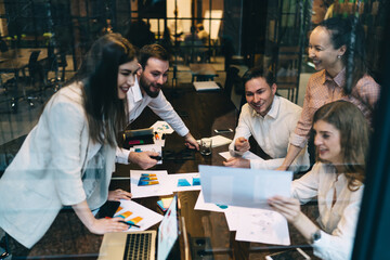 Businesspeople at table with documents and laptop