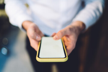 Crop anonymous man browsing smartphone