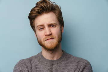 White ginger man with beard frowning and looking at camera