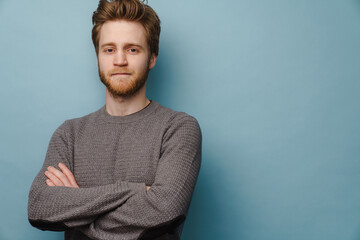 White ginger man looking at camera while posing with arms crossed