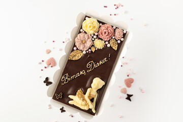 Handmade chocolate from natural ingredients, floral decor, top view, birthday personalized sweet postcard, inscription in Ukrainian, on a white background