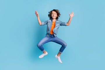 Fototapeta na wymiar Full length photo of young school boy happy positive smile excited jump up isolated over blue color background