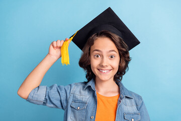 Photo of young school boy happy positive smile diploma mortarboard study isolated over blue color background