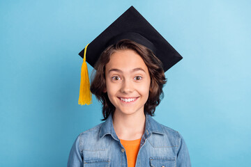 Photo of young school boy happy positive smile wear mortarboard hat student isolated over blue...