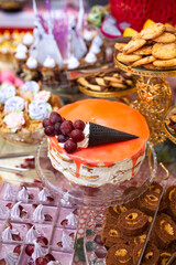 beautiful orange dessert cake on the table with sweets