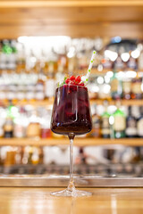summer red cocktail with cranberries on the bar