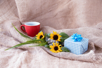 プレゼントとヒマワリの花束とコーヒー（ジュートの背景）