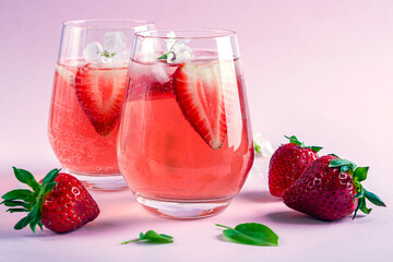 Two glasses of Cooling strawberry Sangria with sparkling wine, strawberry, ice cubes in champagne glass. Refreshing summer alcoholic cocktail drink , lemonade or ice tea.