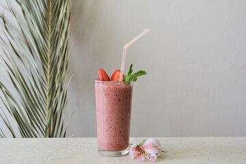 Strawberry smoothie in a glass on the table. Healthy food concept