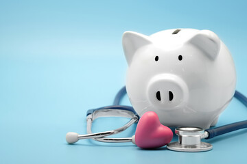 Piggy bank with stethoscope and heart isolated on light blue background with copy space. Health...