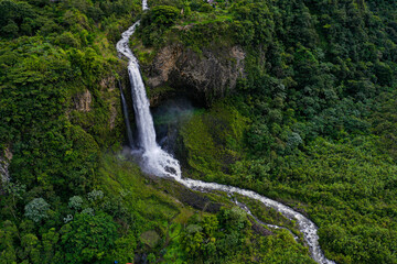 Aerial background of a beautifull waterfall running down a large canyon in the Andes of Ecuador