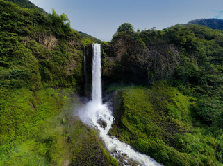 A background with a sideview of a waterfall plummeting down from a high canyon in the Andes of...