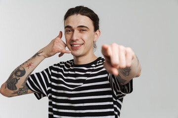 Young white man with earring gesturing and pointing finger at camera