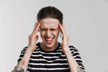 Young white man with headache rubbing his temples