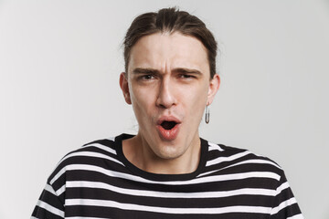 Obraz premium Young white man with earring expressing surprise at camera