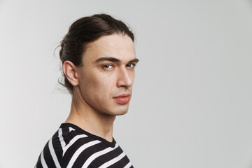 Young white man in striped t-shirt posing and looking at camera