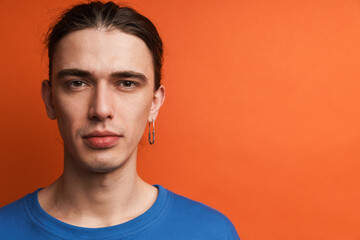 Young white man with earring posing and looking at camera