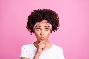 Photo of minded clever woman finger chin look up empty space wear white t-shirt isolated pink background