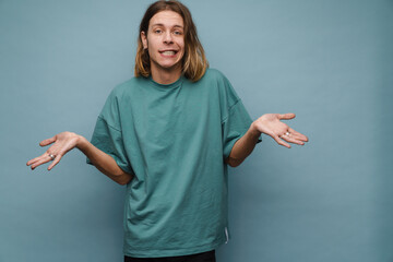 Young white man wearing t-shirt grimacing and gesturing at camera