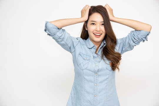 Excited screaming young Asian woman in a blue sky jeans shirt isolated over white background, Looking camera