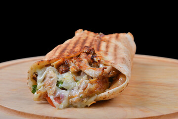 Shawarma sandwich gyro fresh roll of lavash (pita bread) chicken beef shawarma falafel RecipeTin Eatsfilled with grilled meat, mushrooms, cheese. Traditional Middle Eastern snack. On wooden background