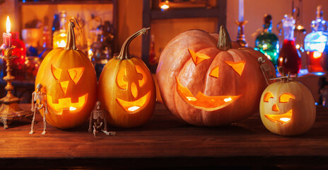 Halloween pumpkins with candles and magic potions at night indoor