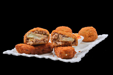 Homemade traditional Spanish croquettes or croquetas on a white plate . Tapas food. black background