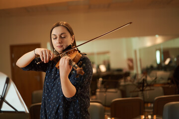 Female violinist performing classical music in hall
