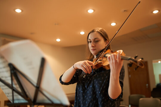 Female violinist performing classical music in hall