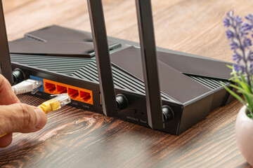 Wireless internet router with connected cables, The backside of fiber optic internet, and network...