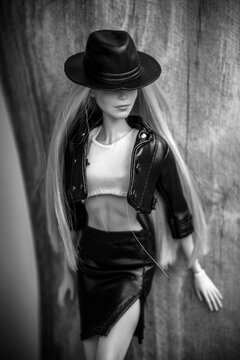 Mulhouse - France - 8 June 2021 - Portrait of blond barbie doll wearing a black leather skirt, white top , black leather jacket and a cowgirl hat standing in outdoor