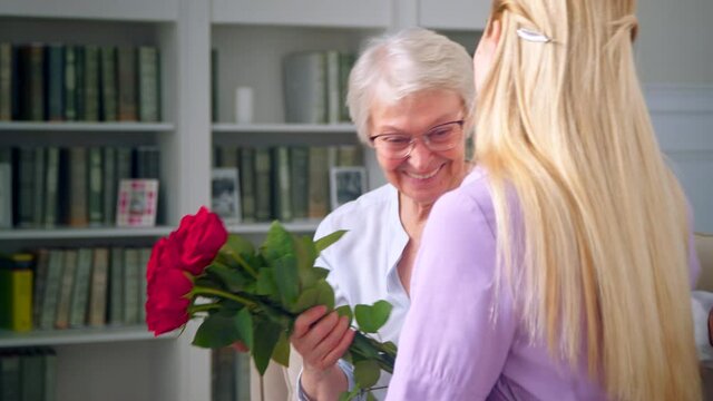 A young girl giving red roses to mother on mother's day