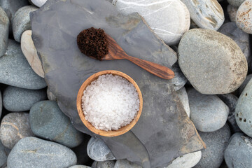 Preparing homemade coffee scrub with himalayan salt on the background of sea pebbles - stock photo