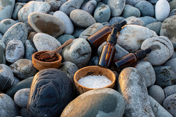 Preparing homemade coffee scrub with himalayan salt and CBD oil on the background of sea pebbles -...
