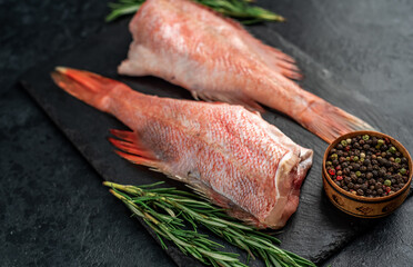 Raw red sea bass fish on stone background