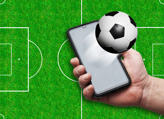 holding a smartphone with football, following soccer FIFA world cup on mobile
