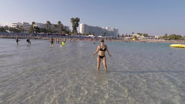 Dancing girl in the Mediterranean Sea on the Nissi beach in Cyprus