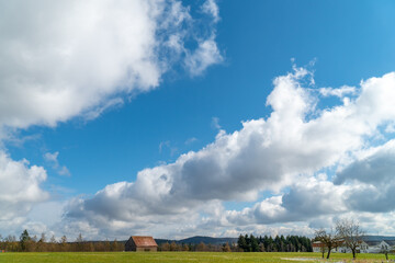 Wolken, Wiese und Wald mit Scheune